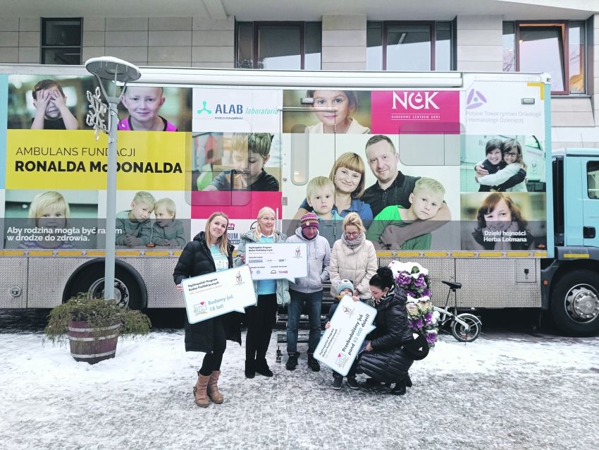 Na zdjęciu osoby przed ambulansem