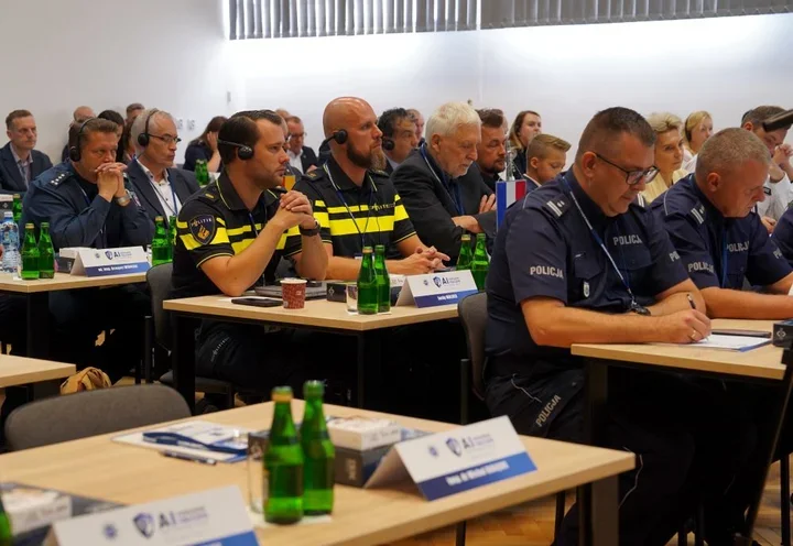 Policjanci uczestniczą w szkoleniu lub konferencji w sali wykładowej.