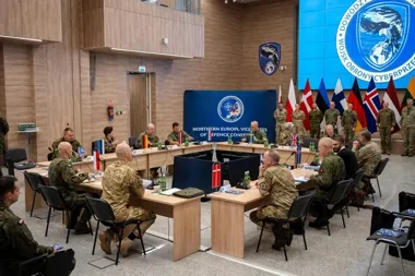 W sali konferencyjnej w Polsce odbywa się spotkanie wicechiefów obrony państw Europy Północnej, z udziałem przedstawicieli wojskowych siedzących przy stole w fo