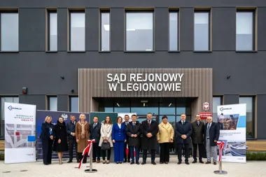 Grupa osób stoi przed nowym budynkiem Sądu Rejonowego w Legionowie podczas uroczystości otwarcia.